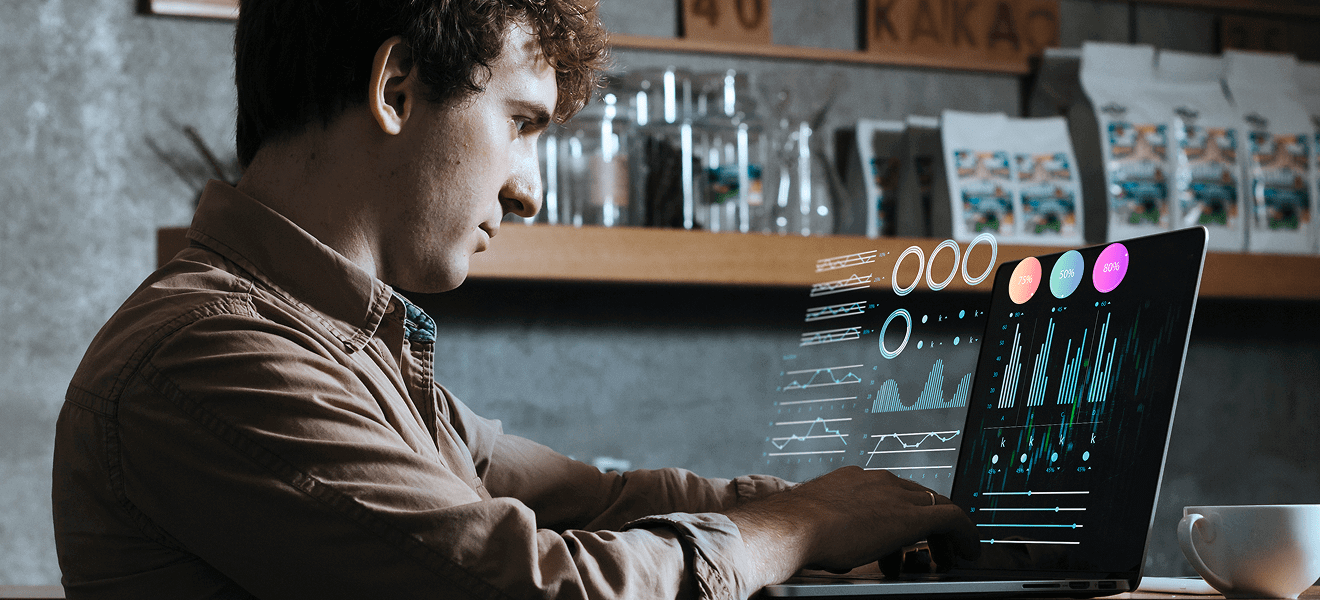 Man working on laptop with holographic analytics
