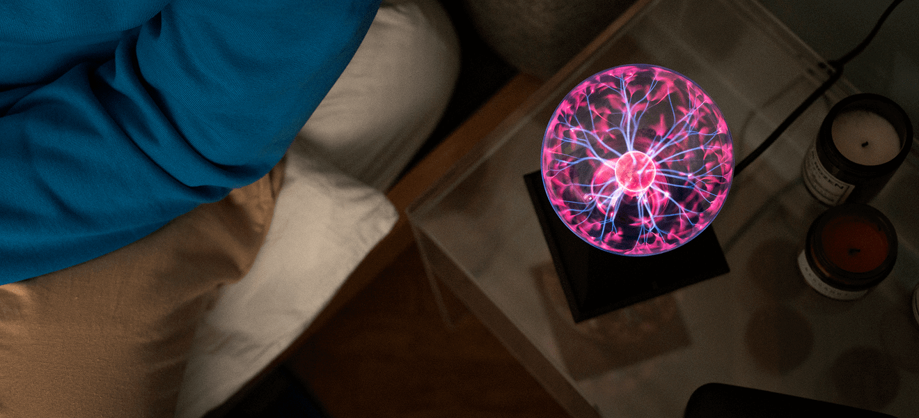 Glowing plasma globe on bedside table